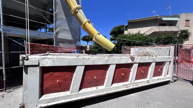 Cantiere con ponteggio, tubo di scarico delle macerie e cassone