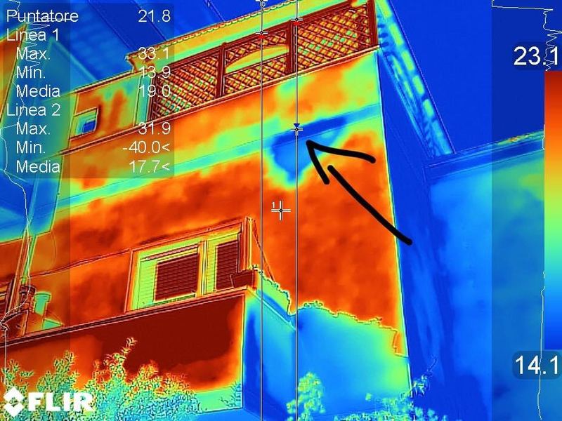 Termogramma di una facciata con un'anomalia termica indicata da una freccia